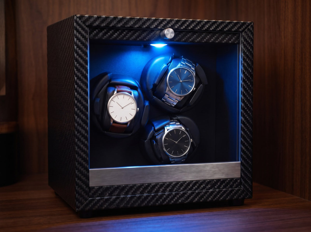 Remontoir automatique Galerie carbone, trois montres sur leurs coussins éclairés en bleu Image