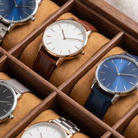 Boîte à montres Cabinet en gros plan, coussins camel et montres dans leurs compartiments