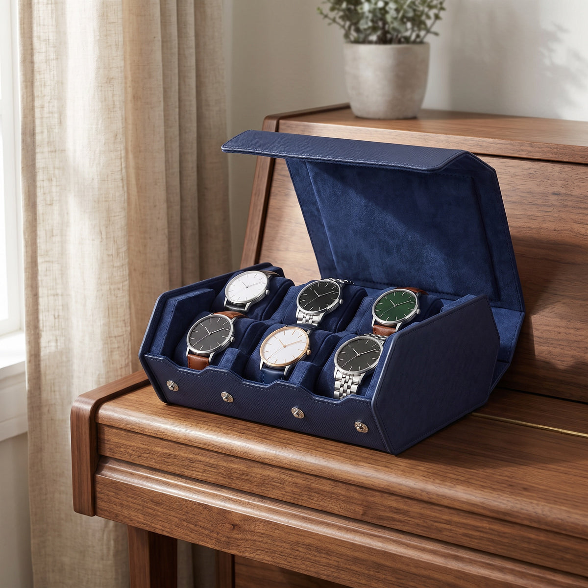 Écrin de voyage Sillage bleu 6 places ouvert et garni de montres, posé sur un piano dans un salon