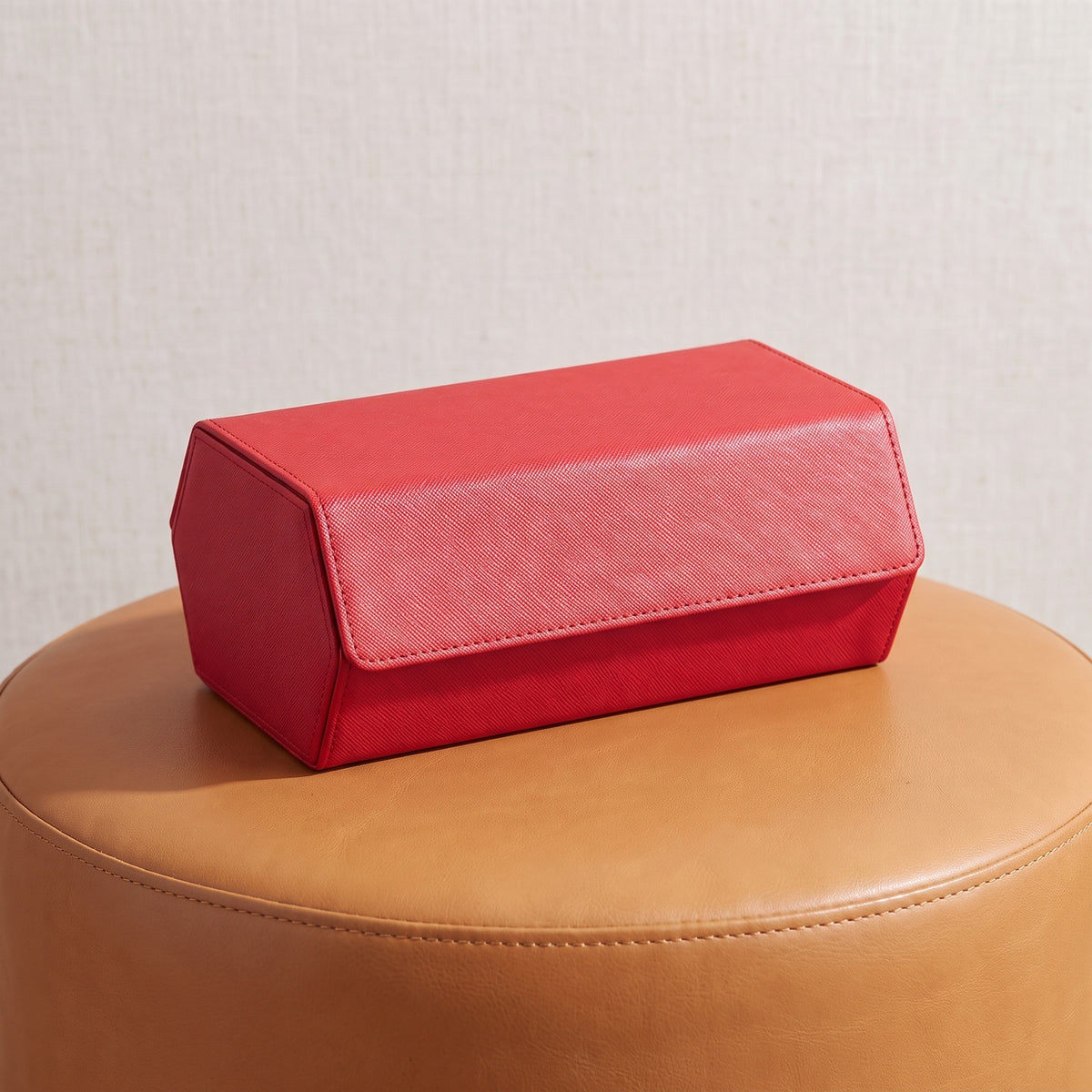 Écrin de voyage Sillage rouge 8 places fermé, posé sur un tabouret en cuir