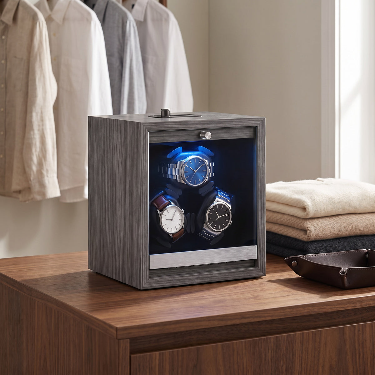 Remontoir pour 3 montres Galerie gris posé sur l'îlot d'un dressing en noyer